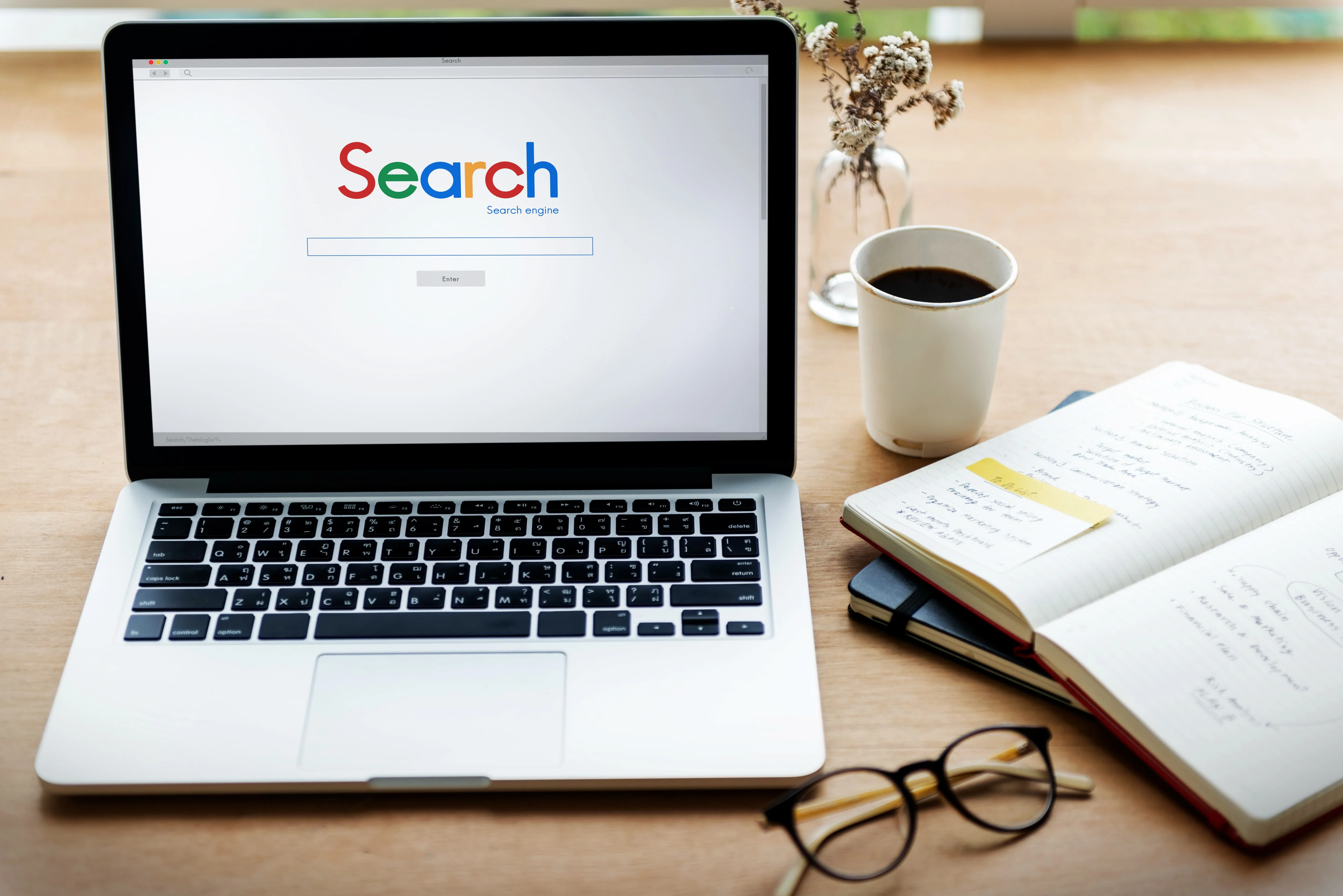 Representation d'un pc avec a l'ecran une barre de recherche pour faire reference au referencement